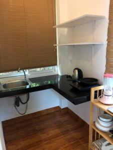a kitchen with a sink and a counter top at Mangrove Beach Houses in Srithanu