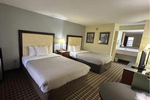 a hotel room with two beds and a television at Quality Inn Byron - Warner Robins in Byron +4 photos
