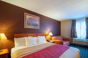 a hotel room with a bed and a chair at Quality Inn Near Pimlico Racetrack in Baltimore