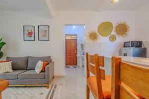 a living room with a couch and a kitchen at Marahaba Holiday Suites Ground Floor 1BR 5 Min Drive to Nomad Beach in Ukunda