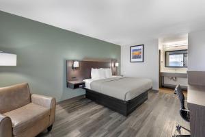 a hotel room with a bed and a chair at Quality Inn Columbus, MS in Columbus +21 photos