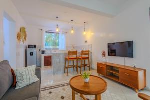 a living room with a couch and a tv and a table at Marahaba Holiday Suites Ground Floor 1BR 5 Min Drive to Nomad Beach in Ukunda
