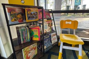 a book shelf filled with books next to a chair at Quality Inn Kenly I-95 in Kenly