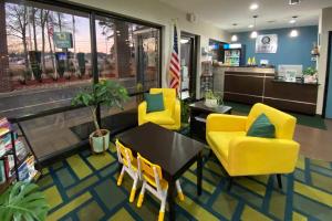 a dining room with yellow chairs and a table and a store at Quality Inn Kenly I-95 in Kenly