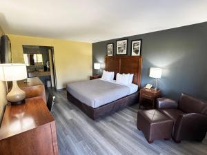 a hotel room with a bed and a chair at Quality Inn Kenly I-95 in Kenly +44 photos