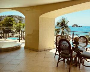 a balcony with a table and chairs and a bath tub at Bay View Grand Ixtapa Exclusive in Ixtapa +16 photos