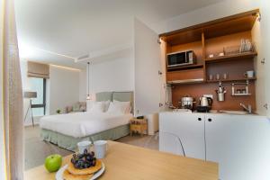 um quarto com uma cama e uma cozinha com uma mesa em NLH FIX | Neighborhood Lifestyle Hotels em Atenas