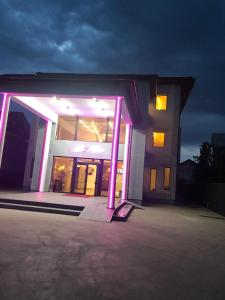 ein Gebäude mit violetten Lichtern an der Vorderseite in der Unterkunft Le Mer in Afumaţi