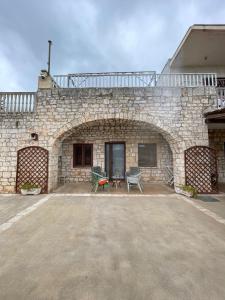 a stone building with a patio with a table and chairs at Villa Coco Monopoli in Monopoli