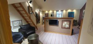 a view of a living room with a tv and chairs at Maison PARAGONE in Bergues