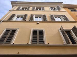a tall yellow building with shuttered windows at Small Luxury In Centro Storico in Parma