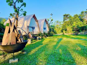a man sitting in a chair next to a tree at Sống Chill Homestay in Nam Yên