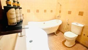 a bathroom with a white toilet and a sink at Mara Villa Katunayake - 5 Mins to Colombo Airport in Katunayaka +30 photos
