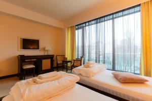 two beds in a room with a large window at Hotel Zodiac by Sofra in Constanţa