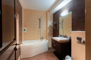 a bathroom with a tub and a toilet and a sink at Hotel Zodiac by Sofra in Constanţa +43 photos