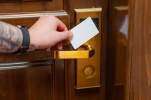 a person unlocking a door with a piece of paper at Hotel Zodiac by Sofra in Constanţa