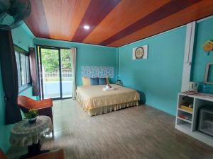 a bedroom with blue walls and a bed in a room at Good View Guest House in Phatthalung