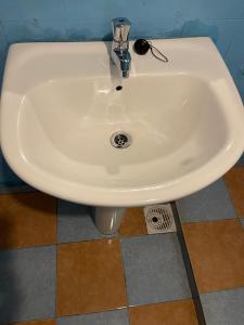 a white sink in a bathroom with a tile floor at Coconut beach in Bentota