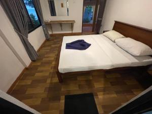 a bedroom with a bed with a blue shirt on it at Coconut beach in Bentota +16 photos