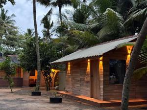 a wooden cabin with palm trees in front of it at Coconut beach in Bentota