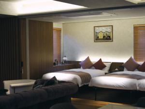 a hotel room with two beds and a couch at The GOAT AWAJI in Kusumoto