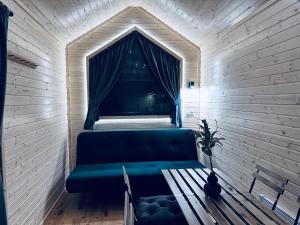 a blue couch in a room with a window at Stockholm Archipelago by Tiny Away in Fagerdala