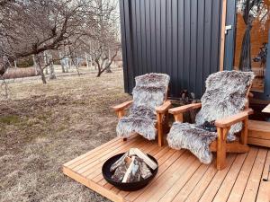 two chairs on a wooden deck with a fire pit at Stockholm Archipelago by Tiny Away in Fagerdala
