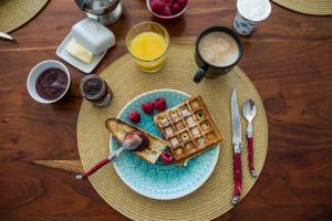 a plate of waffles and fruit on a table at Les Cuves - Saintes - Chambres d'hôtes et gîte in Saintes