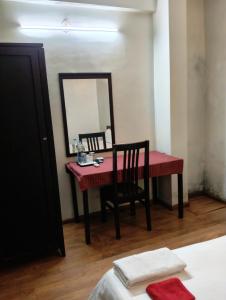 a bedroom with a table with a mirror and a chair at Hotel Maurya Regency in Morjim +51 photos