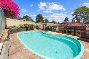 a swimming pool in the backyard of a house at Escape from Relaxing Poolside House 3B in Narellan +2 photos