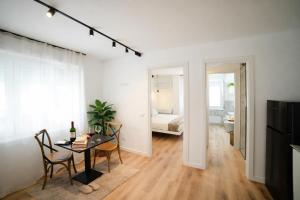 a white apartment with a dining room table and a bedroom at Residenza Ximenes Hub in Palermo