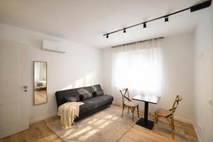 a living room with a black couch and a table at Residenza Ximenes Hub in Palermo