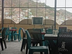 a restaurant with tables and chairs and a computer monitor at Hotel Ajmer Pride in Ajmer