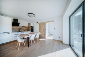 a kitchen and dining room with a table and chairs at Kotva By Momoland - Apartmán in Ružiná +11 photos