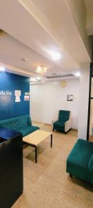 a living room with two green couches and a couch at Open Hotel by Olive - Sadha Siva Airport Road, Chennai in Chennai