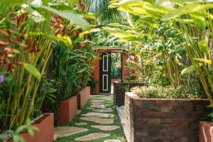 a garden with a pathway with plants and a black door at Lasai Villas in Gili Islands