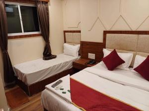 a hotel room with two beds and a window at Hotel Ashirwad Inn in Mumbai