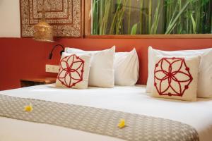 a bedroom with a bed with white sheets and pillows at Lasai Villas in Gili Islands +41 photos