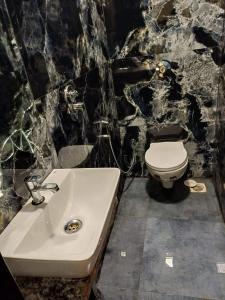 a bathroom with a white toilet and a sink at Hotel Ashirwad Inn in Mumbai