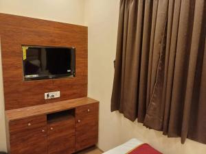 a room with a television on a dresser with a window at Hotel Ashirwad Inn in Mumbai +23 photos