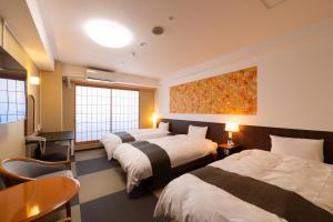 a hotel room with three beds and a painting on the wall at Hotel Sekumiya in Obama +19 photos