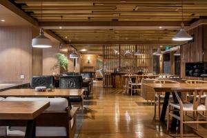 a restaurant with wooden floors and tables and chairs at 两江万励OneJasper空中江景酒店 in Chongqing