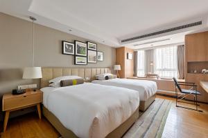 a hotel room with two beds and a desk at 两江万励OneJasper空中江景酒店 in Chongqing