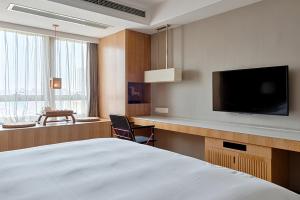 a hotel room with a bed and a flat screen tv at 两江万励OneJasper空中江景酒店 in Chongqing