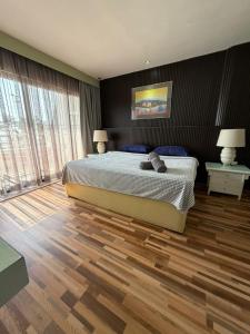 a bedroom with a bed and a wooden floor at The Regency PortDickson A1-6 in Port Dickson