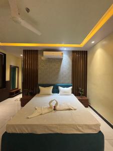 a bedroom with a bed with two towels on it at Hotel Golchi Palace in Lālsot +48 photos