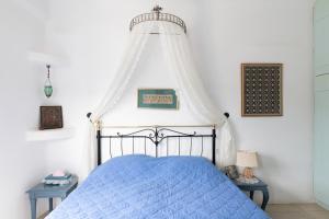 a bedroom with a blue bed with a canopy at Villa Fani Kythnos in Kithnos