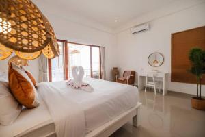 a bedroom with a white bed with a heart on it at Villa OG Cruz in Canggu +43 photos