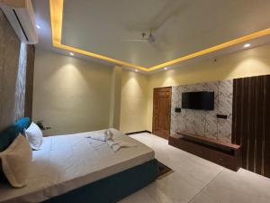 a bedroom with a bed and a tv on the wall at Hotel Golchi Palace in Lālsot