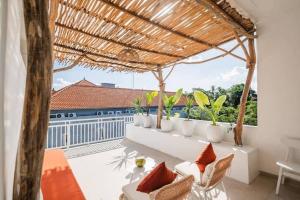 a porch with chairs and a pergola with a view at Villa OG Cruz in Canggu